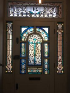 White wooden door with stain glass designs