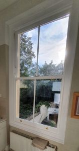 large white sash window over looking back garden